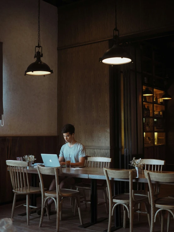 a man is sitting at a table with a laptop