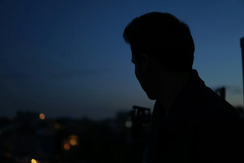 the back of the man is visible on a night time street