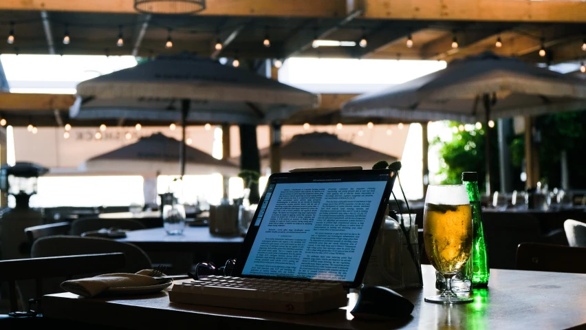 a laptop sitting on top of a table in a restaurant