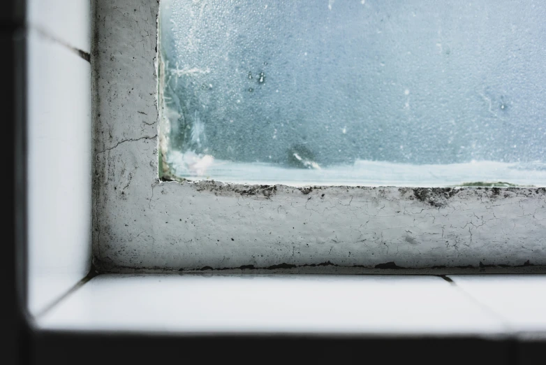 a window with a white corner next to a brown window sill