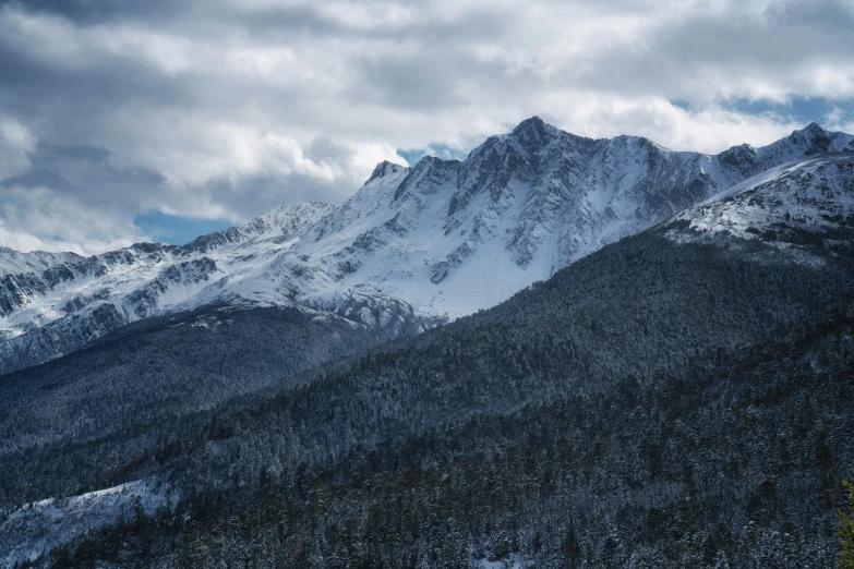 some snow covered mountains on a cloudy day