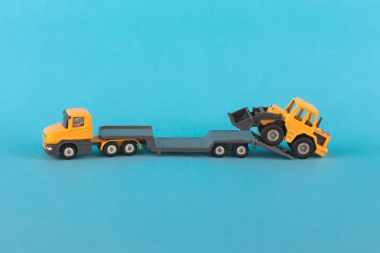 yellow toy truck pulling a trailer and trailer