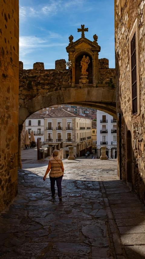 the woman is walking through the narrow alley