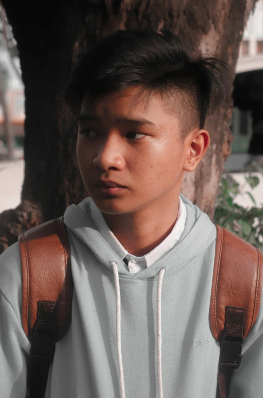 young asian man with backpack on holding an apple