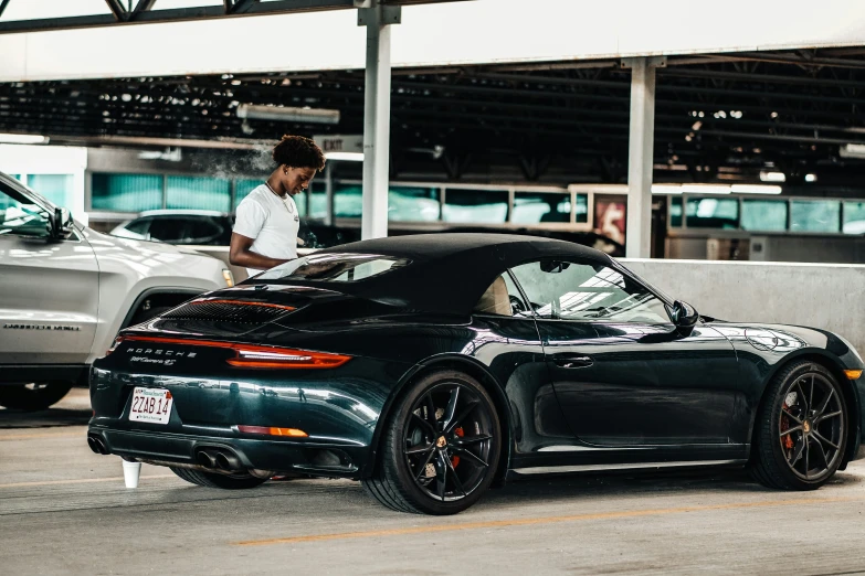 black porsche car sitting in front of silver porsche on the street