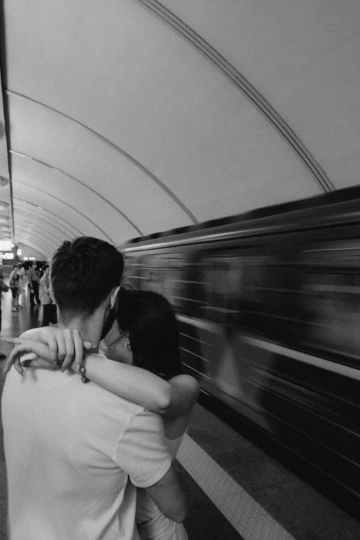 a man is hugging the neck of a young woman