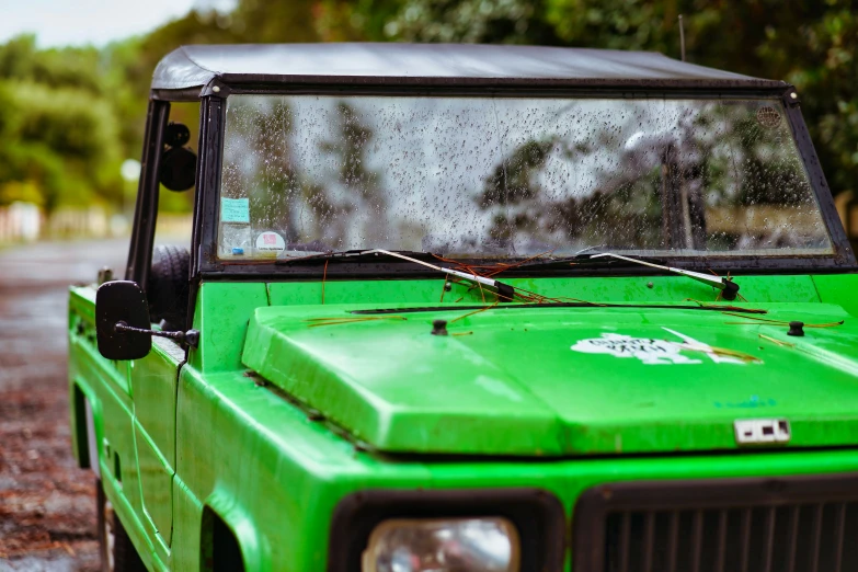 a green truck parked on the side of the road