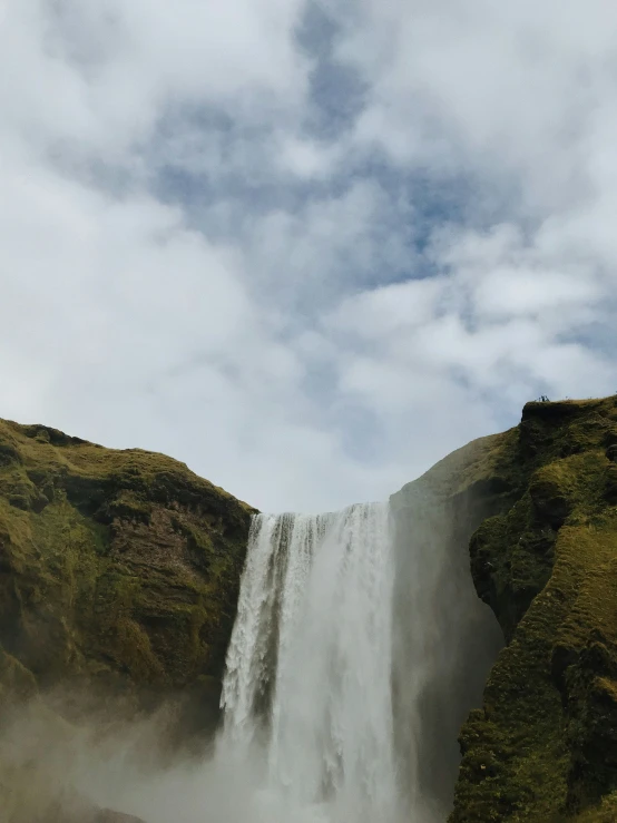 a waterfall rises into the sky in the distance