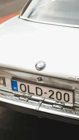 an old car's license plate has blue writing on it