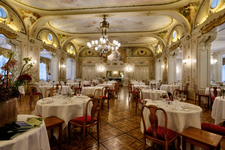 a fancy dining room with white linens and gold details