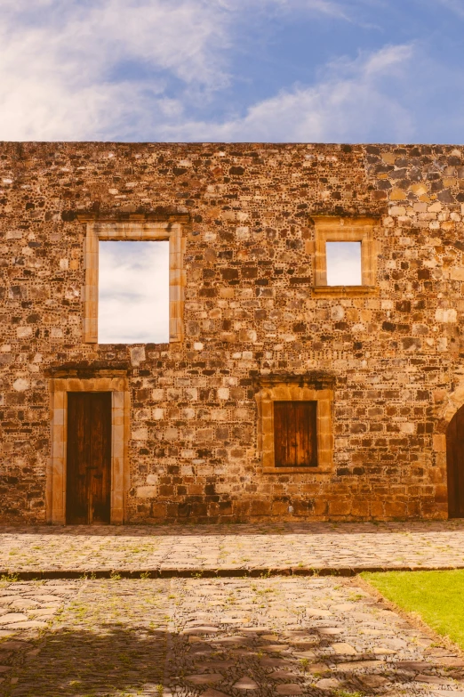 an old building made of bricks with three open windows