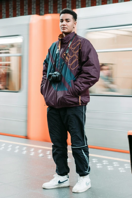 a man is standing on the platform, wearing a jacket