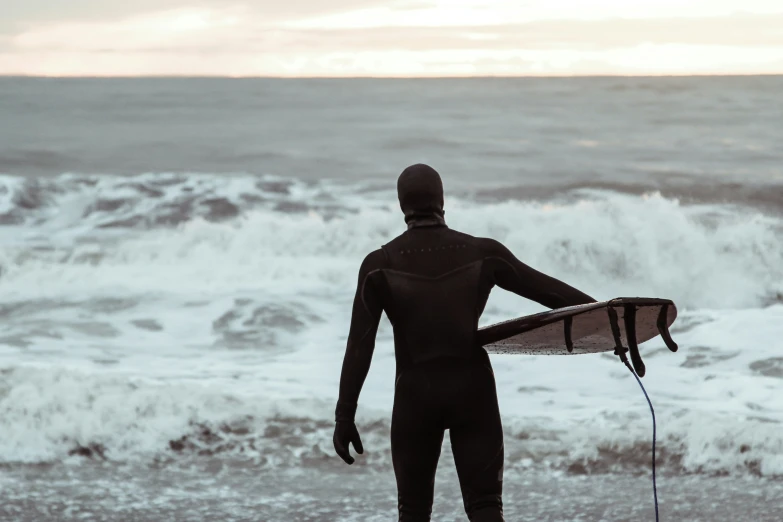 a person with a surf board looking into the water