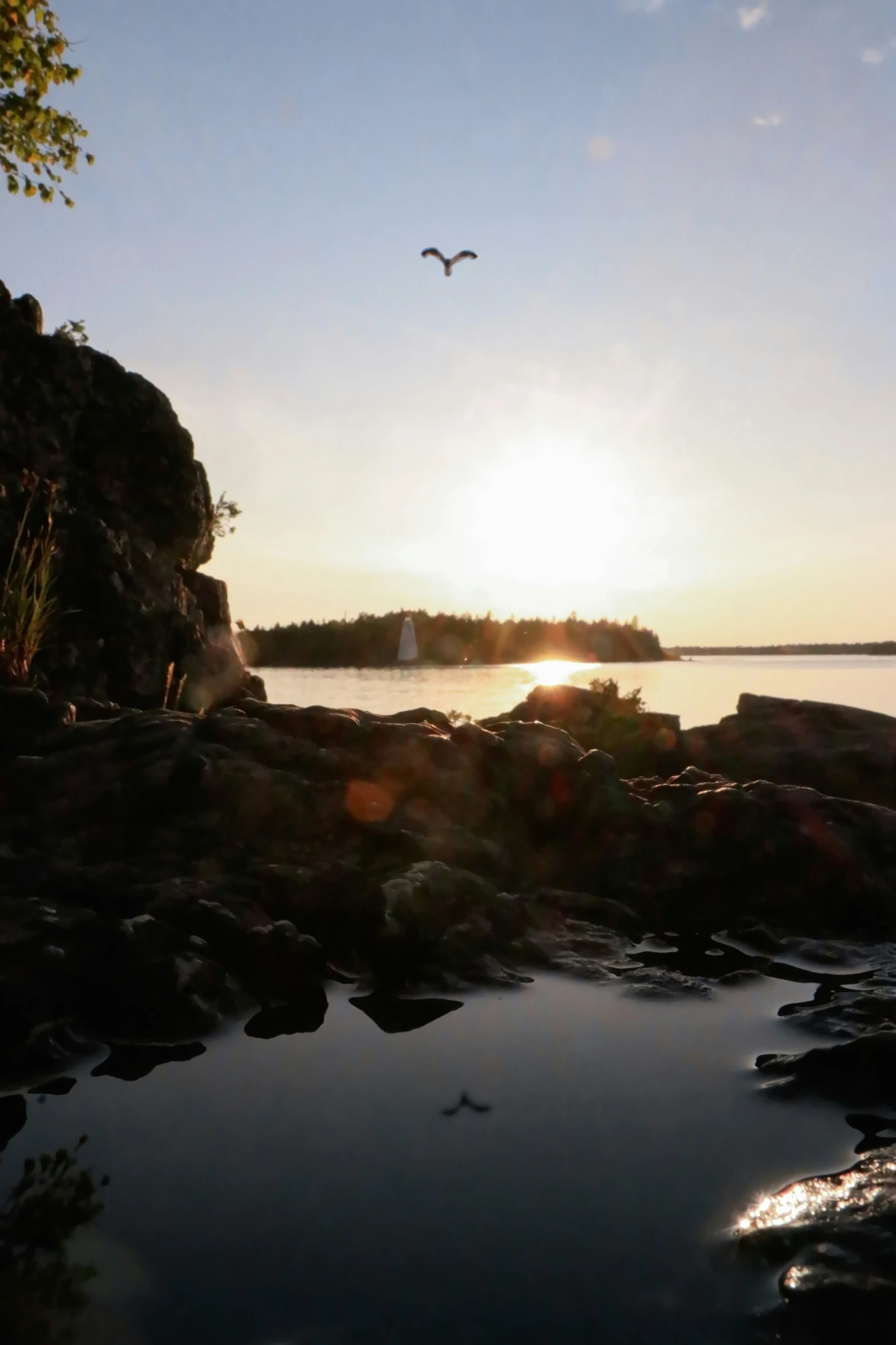 a lake filled with rocks and birds flying over it