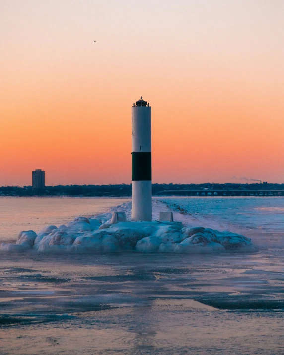 a light tower sitting next to the ocean