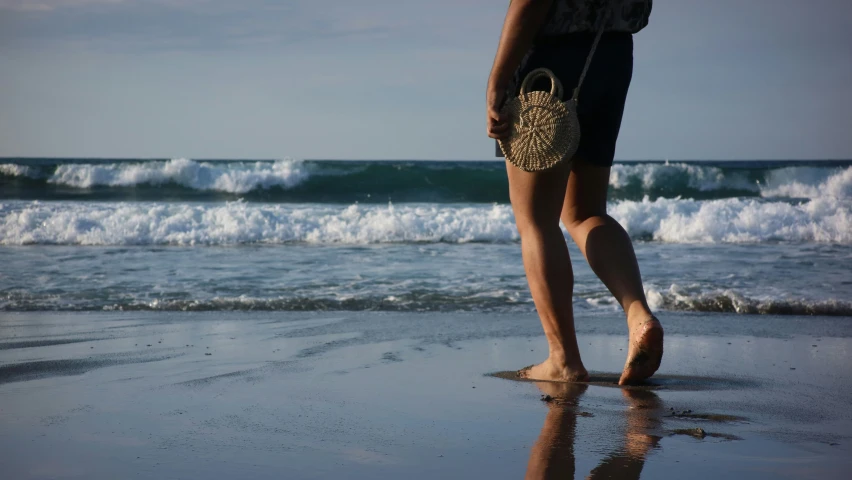 a woman standing on top of a beach next to the ocean