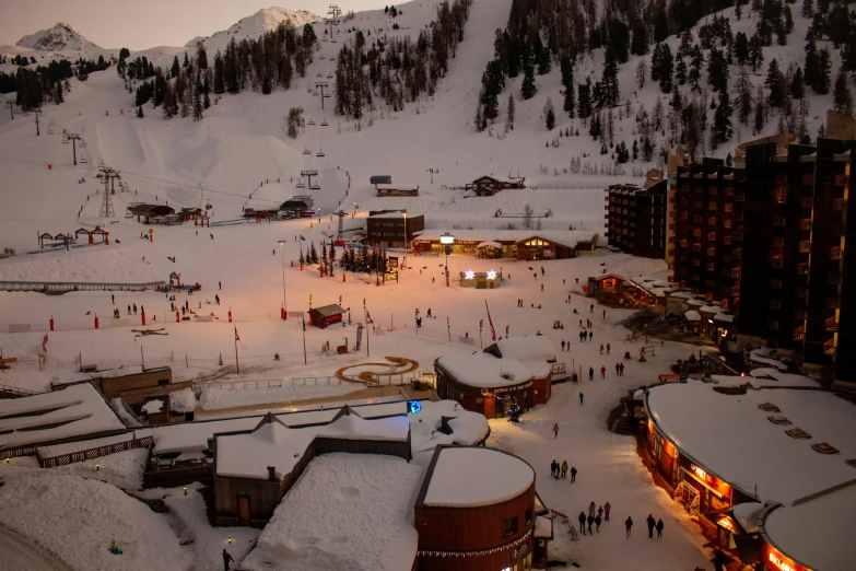snow covered ski slopes with people outside at night