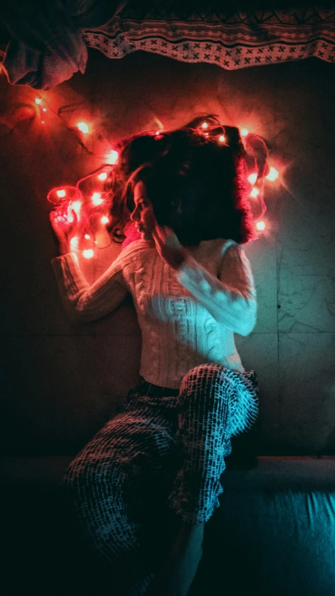 a woman sitting on top of a couch under a light