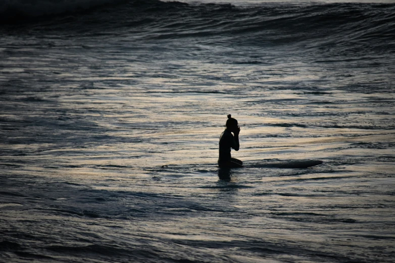 a man with his hand on his face stands in the water