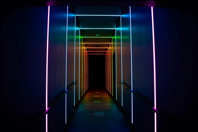 a long hallway with brightly colored light beams in the hallway