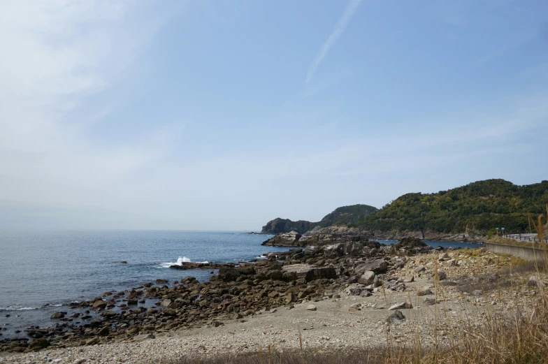 an outcropping of rocks sits on the beach by the ocean