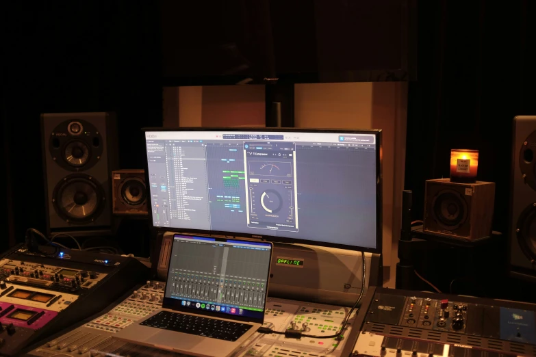 an empty computer monitor sitting above a sound mixing board
