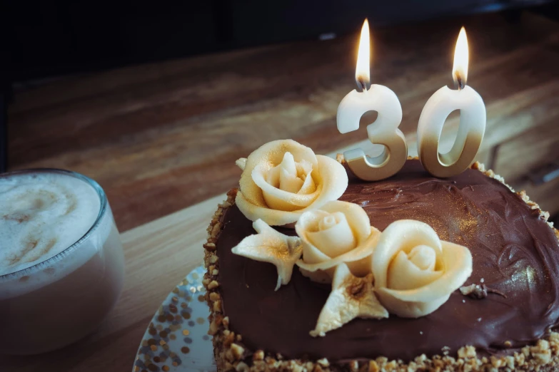 a chocolate cake with flowers and candles sitting on a table