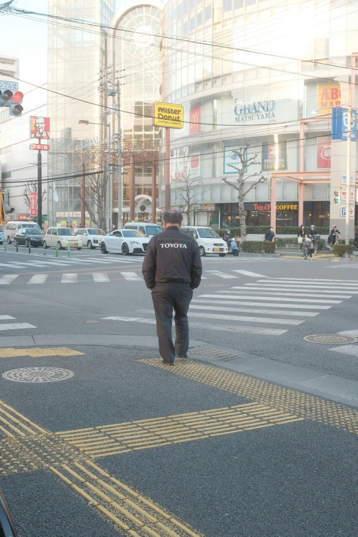 a man walking across a street on a cloudy day