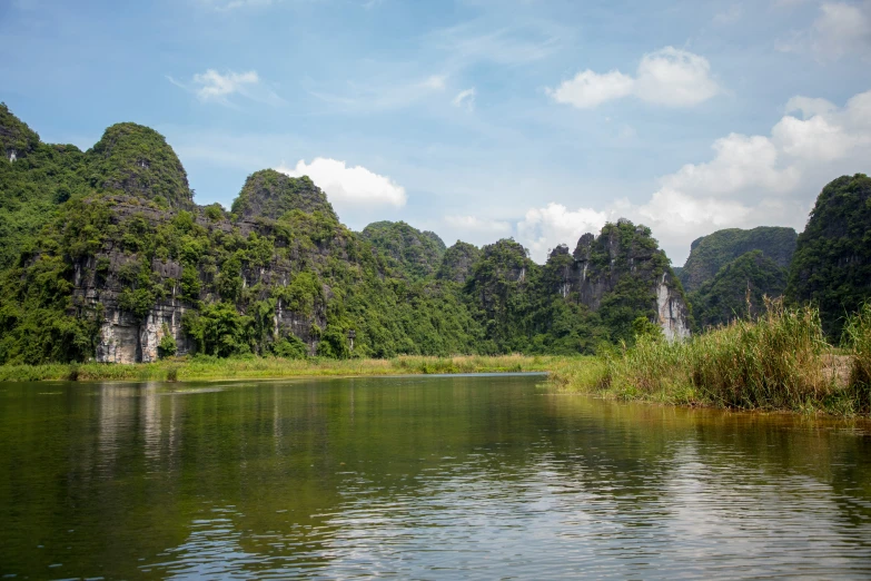 calm water sits on the bank next to lush green mountains