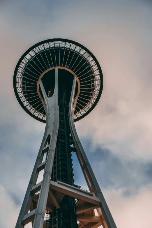 the space needle looks up into the cloudy sky