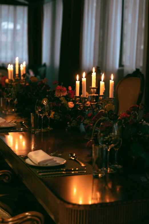 a table covered in candles and flowers is set for a celetion