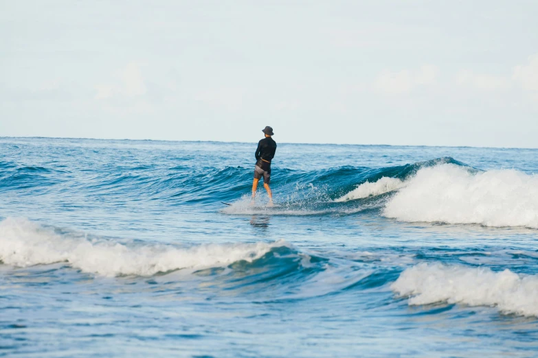 a man riding a surfboard on top of an ocean wave