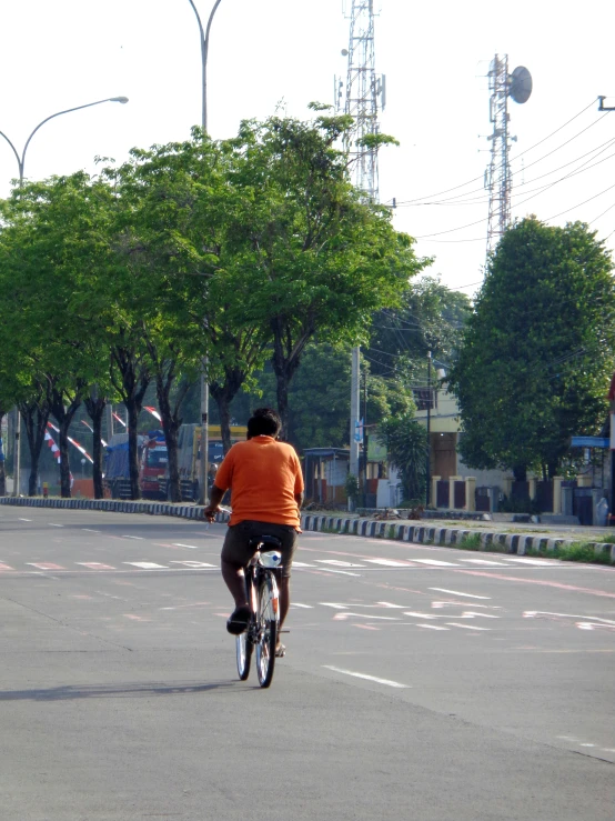 a man in an orange shirt rides a bike