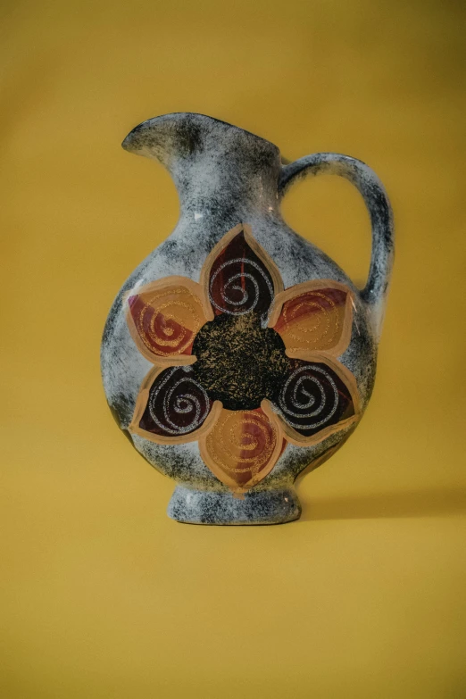 a gray vase with multi - colored designs on the inside of it