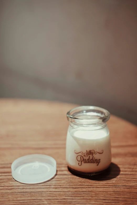 small jar with white whipped toppings on a wooden surface