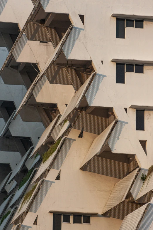 buildings with triangular shaped windows and green plants on the side