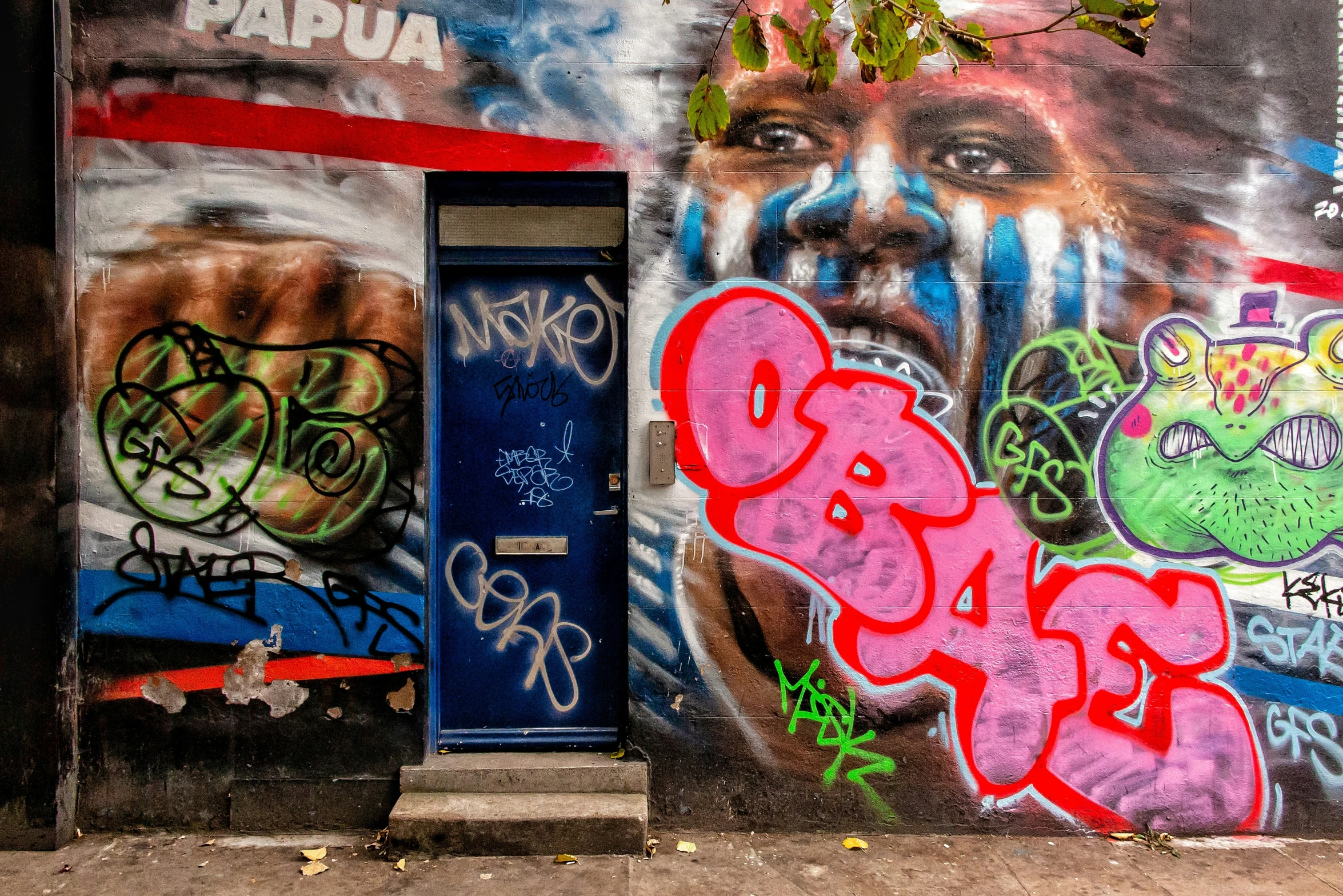 graffiti on a wall, featuring different color styles of face