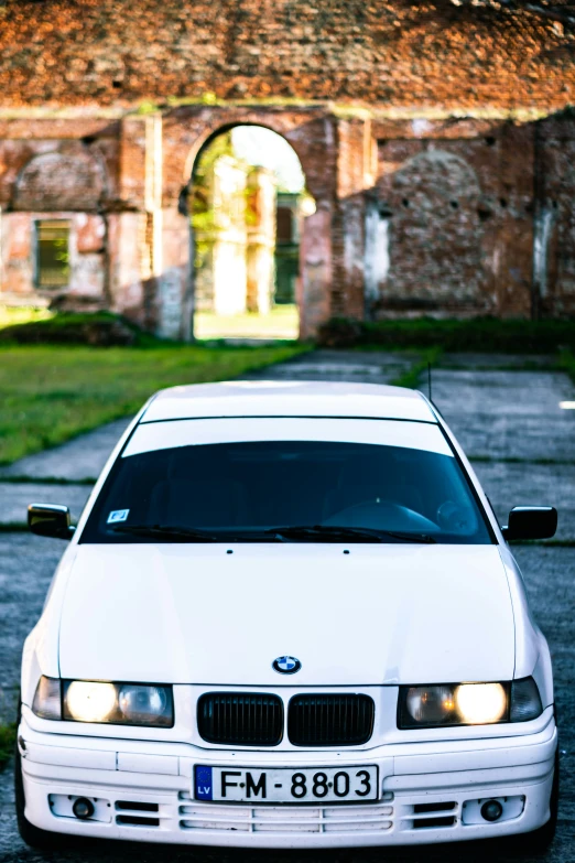 a white car parked in front of an old building