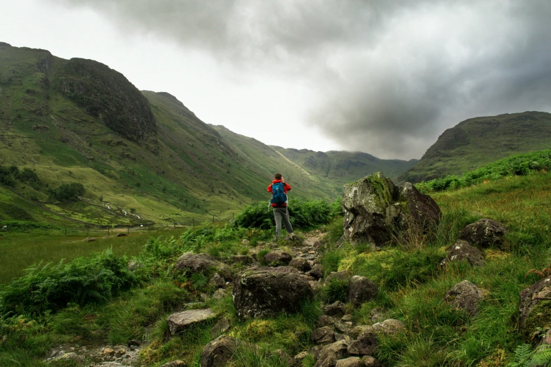 a lone hiker looks down on the valley below