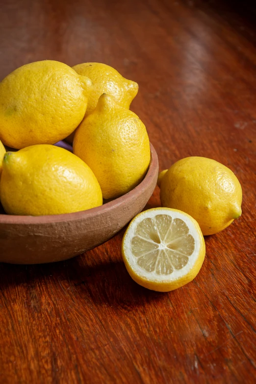 a bowl full of lemons on a table