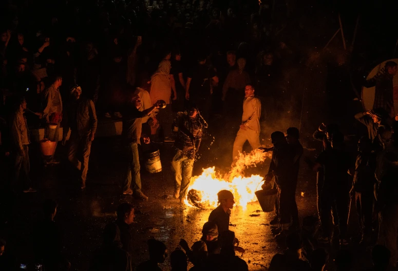 some people sitting around a fire on a street