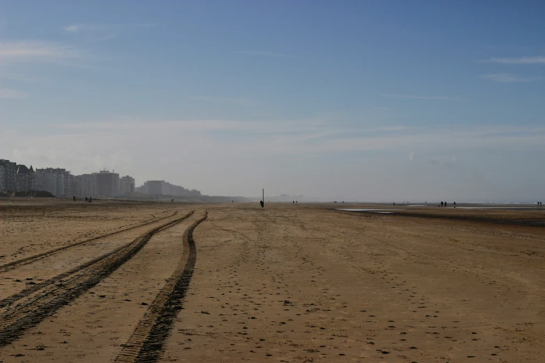 a beach with several tracks that lead into the sand