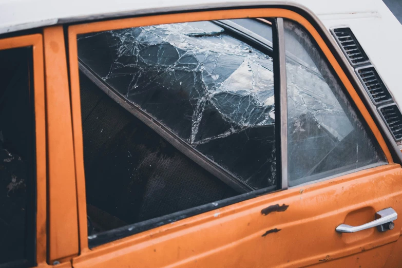 an orange car with broken windows on the side