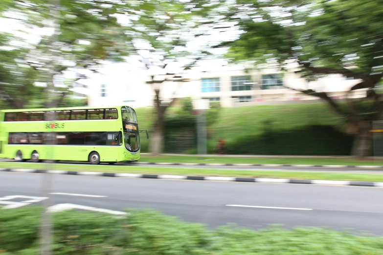 a yellow double decker bus driving down a road