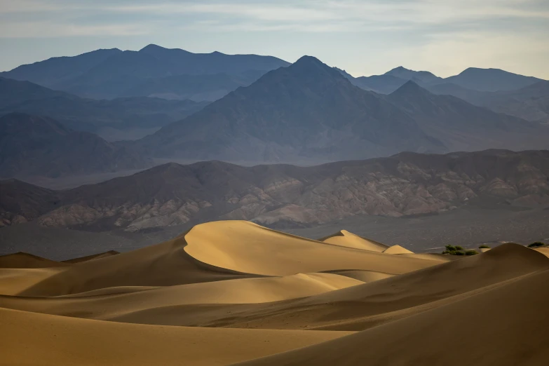 desert mountains with trees and sand dunes with no water