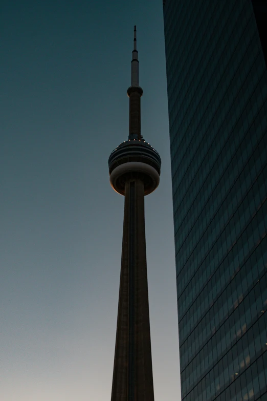 a tall building with a spire has it's reflection on another tower