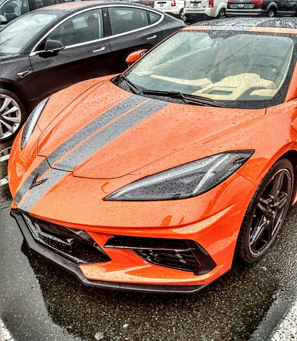 an orange sports car is sitting in a lot