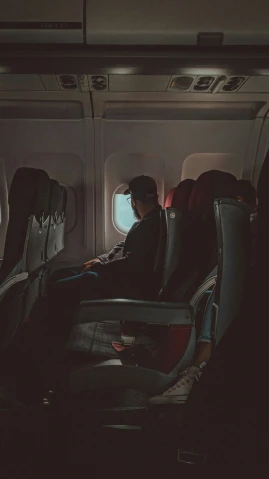 man sitting inside airplane seat next to window