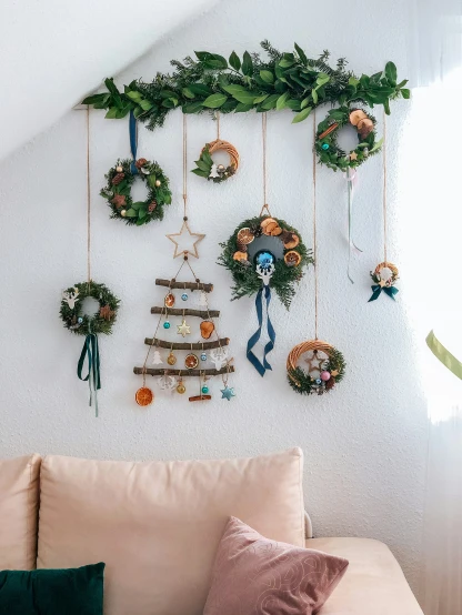 a wall hanging covered in plants and wreaths