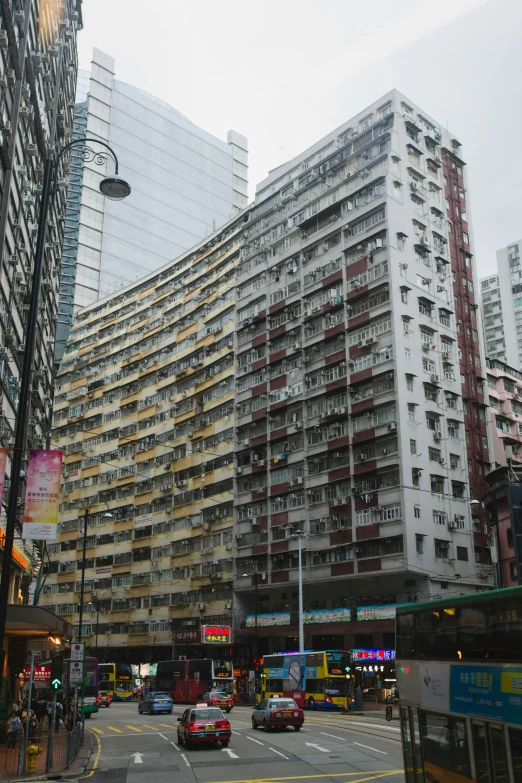 some cars driving down the street near some tall buildings